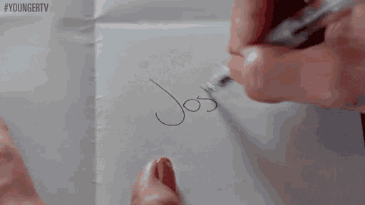 a person is writing the name josh on a piece of paper with a marker .