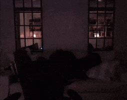a person laying on a couch in a dark room