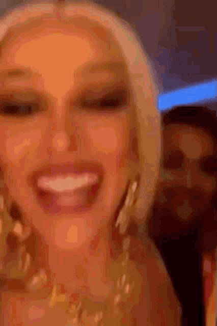 a woman is smiling with a man behind her .