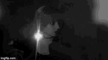 a black and white photo of a woman holding a light in her hand .