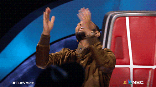 a man is sitting in a chair with his hands in the air and the words nbc on the bottom