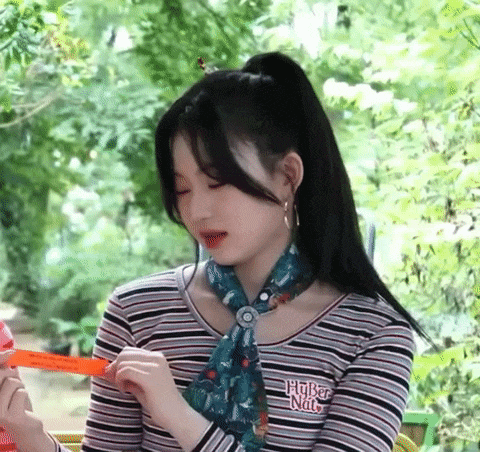 a girl in a striped shirt and scarf is holding a ruler in her hand .