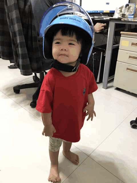 a little girl wearing a helmet that says baby shark on it
