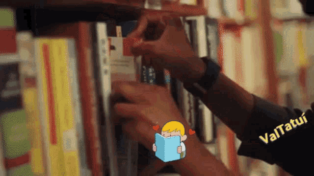 a person wearing a black shirt that says vatatui is reaching for a book
