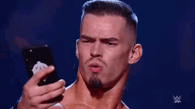 a man is taking a selfie with his cell phone on a stage .