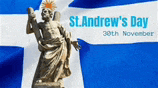 a statue of jesus is standing in front of a blue and white flag .