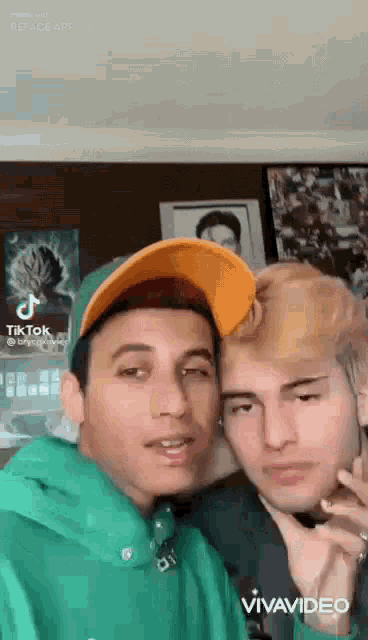 a couple of young men are posing for a picture together .