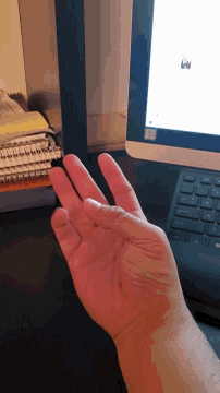 a person 's hand is reaching out towards a keyboard that has the letter a on it
