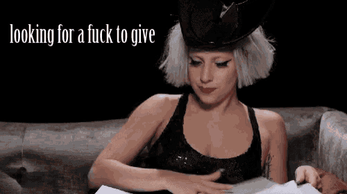 lady gaga is sitting on a couch reading a book with the words looking for a fuck to give above her