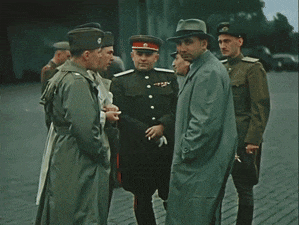 a group of men in military uniforms and hats are standing around talking