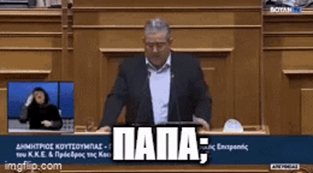 a man in a suit is giving a speech in front of a podium with the word papa written on it .