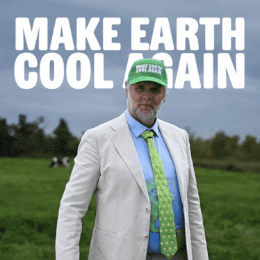 a man wearing a green make earth cool again hat stands in a grassy field