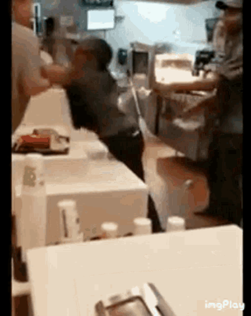 a group of people are standing around a table in a restaurant kitchen .