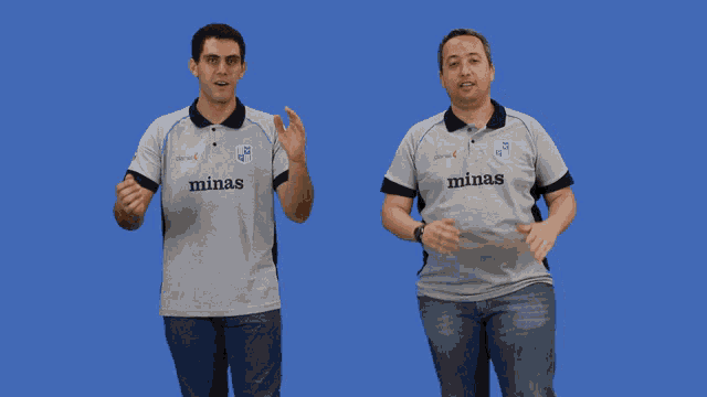 two men wearing minas polo shirts are dancing