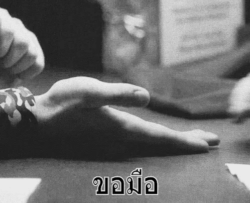 a black and white photo of a person 's hand with a foreign language written below it .