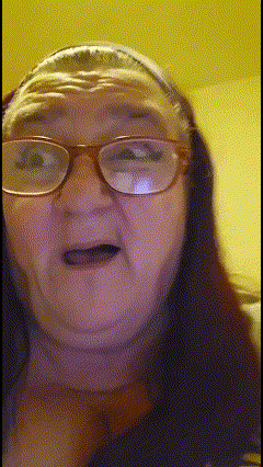a woman wearing glasses and a headband looks at the camera