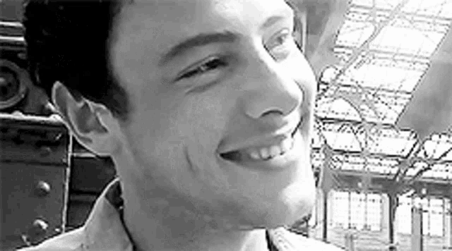 a black and white photo of a young man smiling .