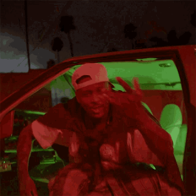 a man is sitting in a car with a green light behind him