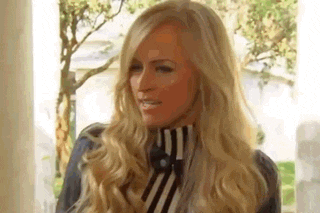 a woman with long blonde hair is wearing a striped turtleneck and tie .