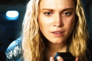a close up of a woman holding a cell phone in her hand