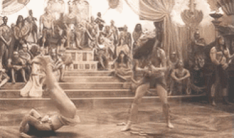 a black and white photo of two women dancing in front of a crowd of people .