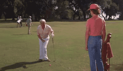 a group of people are playing golf on a green field .