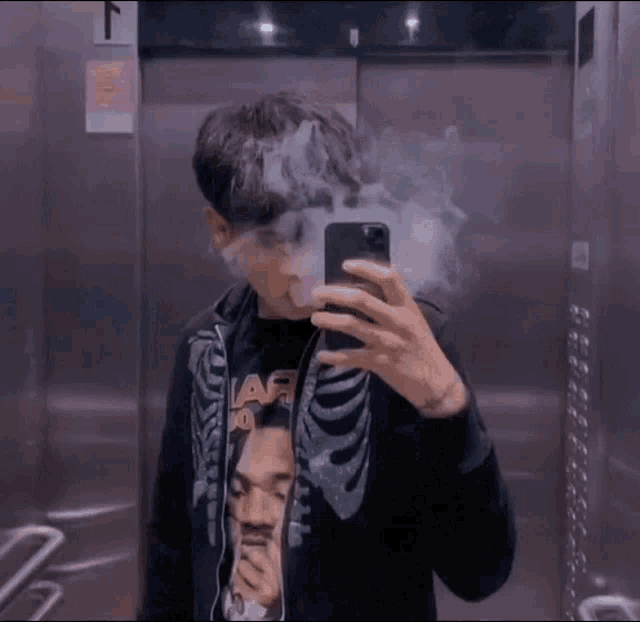 a man in a skeleton jacket is smoking a cigarette in front of a mirror
