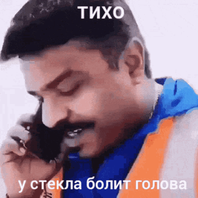 a man with a mustache is talking on a cell phone with a caption that says tixo