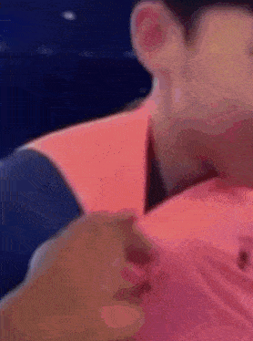 a close up of a person 's neck and shoulder with a pink shirt on