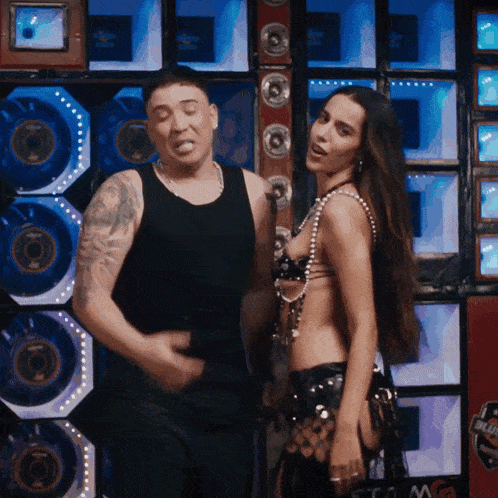 a man and a woman are dancing in front of a wall that has a sticker on it that says ' blitz '