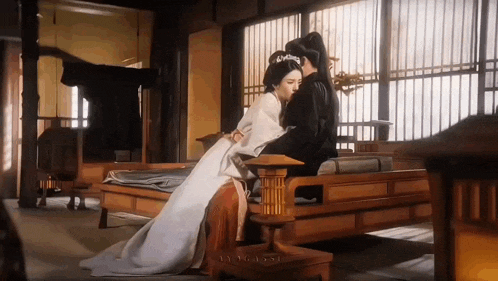 a man and a woman are sitting next to each other on a couch in a room .
