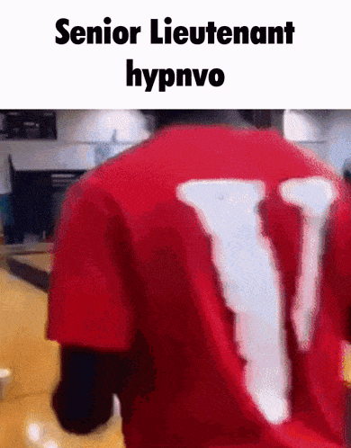 a man is wearing a red shirt with the letter v on it