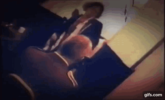 a man in a suit is sitting on a couch in a dark room .
