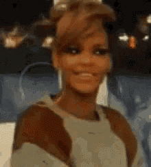 a woman is smiling and looking at the camera while sitting in a chair .