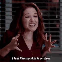 a woman is making a funny face while saying `` i feel like my skin is on fire ! ''