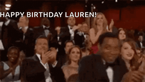 a crowd of people are applauding at an awards ceremony and the words `` happy birthday lauren '' are being displayed .