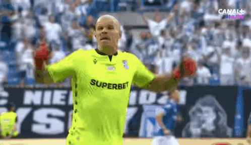 a soccer player wearing a yellow jersey that says superbet on it