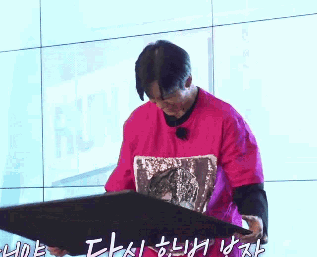 a man in a pink shirt is holding a piece of paper with the word run on it