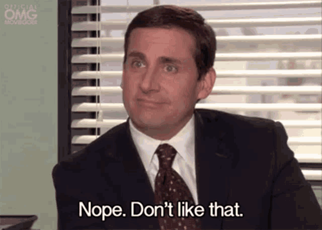 a man in a suit and tie is sitting at a desk .