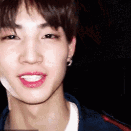 a close up of a young man 's face with his mouth open and a smile on his face .