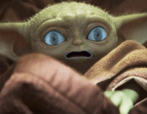 a close up of a baby yoda with big blue eyes
