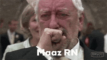 a man in a suit and tie is crying while covering his mouth with his hand .