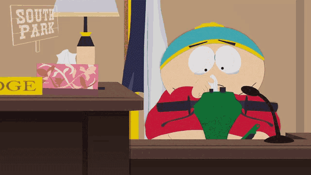 a cartoon character from south park is sitting at a desk