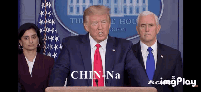 a man in a suit and tie stands at a podium and says chin na