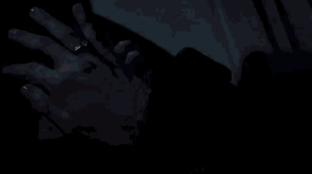 a man and a woman are holding hands and the woman is wearing a ring on her finger .