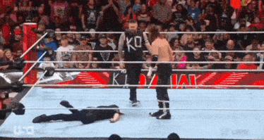 a wrestler in a ko shirt is standing in the ring