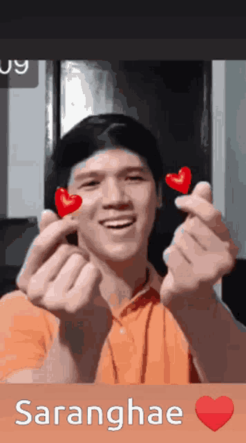 a man making a heart shape with his hands with the name saranghae on the bottom