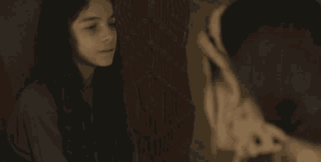 a girl with a headband on her head is looking down