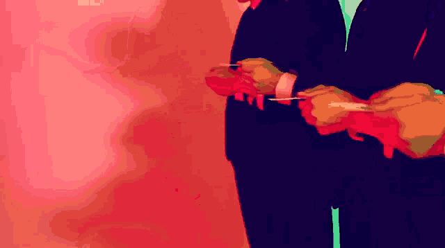 a man in a suit holds a red object in his hands