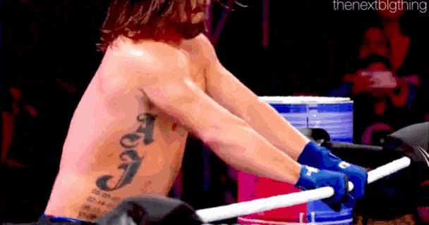 a shirtless man with a tattoo on his back is holding a stick